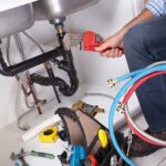 plumber-with-tools-and-washing-machine-pipes